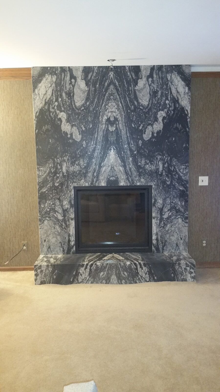Floor-to-ceiling granite fireplace surround